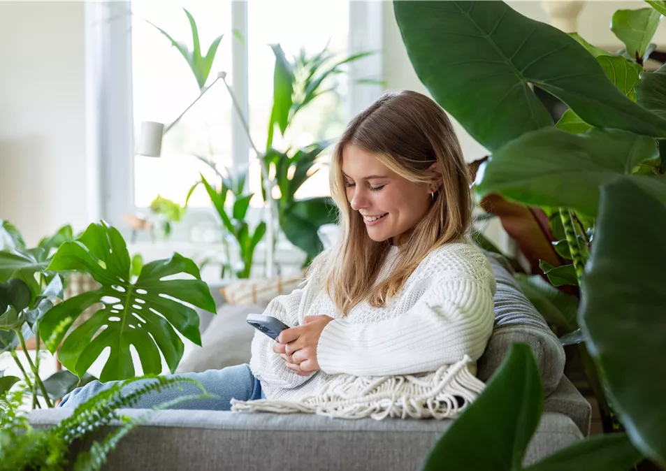 Jungle Ambiente - Frau mit Handy auf dem Sofa