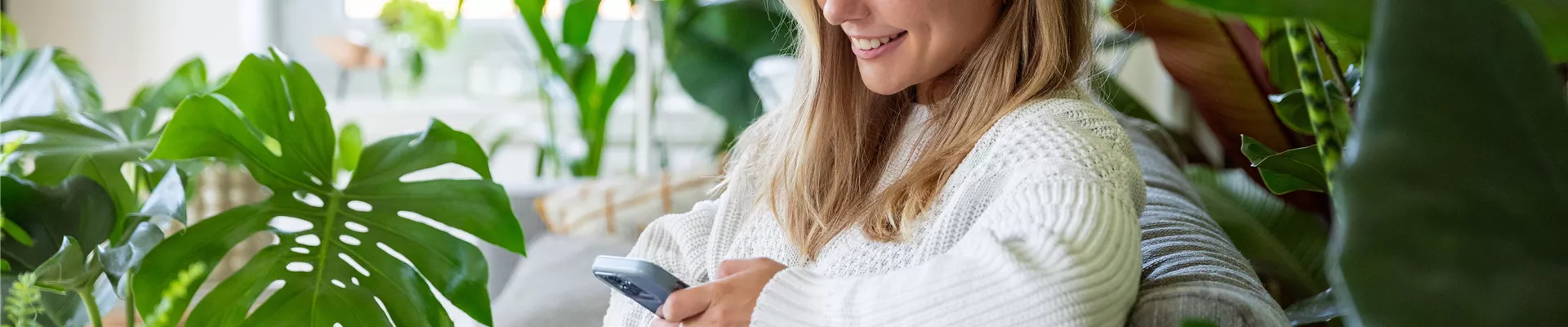 Jungle Ambiente - Frau mit Handy auf dem Sofa Jungle Ambiente - Frau mit Handy auf dem Sofa